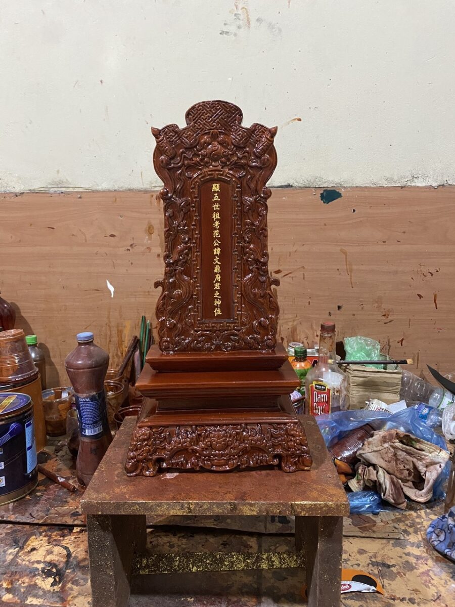 Nghệ nhân và thợ Xưởng Đồ Thờ Trần Hùng trực tiếp đục chạm bài vị gỗ tại Sơn Đồng.